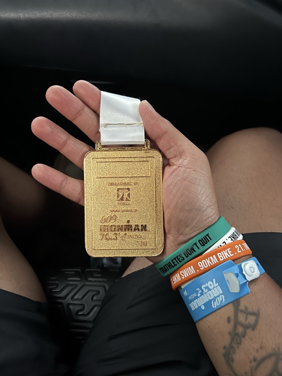 Ironman 70.3 finisher medal closeup with race wristbands